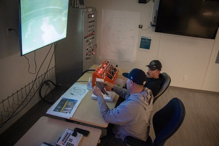 Hanford Tank Waste Operations & Closure nuclear chemical operators, Enoc Flores, left, and Trace Martin, discuss the contents of Tank A-102 during the final days of waste retrieval field operations.